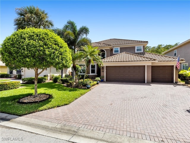 mediterranean / spanish-style house with a garage and a front lawn