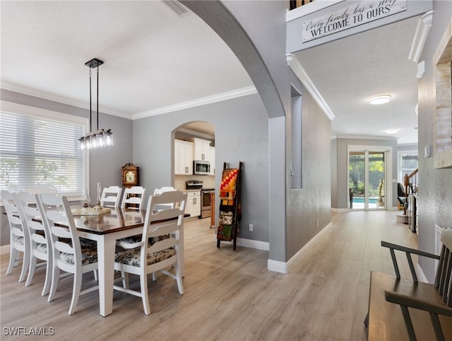 dining space featuring crown molding, plenty of natural light, and light hardwood / wood-style flooring