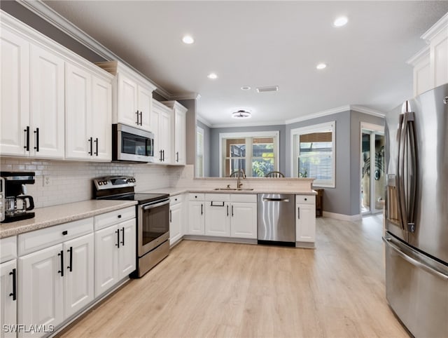 kitchen featuring crown molding, appliances with stainless steel finishes, sink, and white cabinets