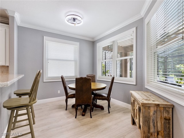 dining space with light hardwood / wood-style floors and ornamental molding