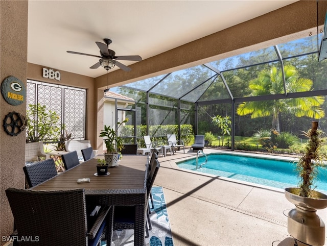 view of pool featuring glass enclosure, ceiling fan, and a patio