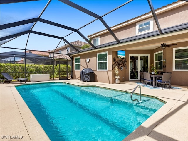 view of pool with a grill, ceiling fan, a patio area, and glass enclosure