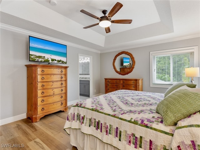 bedroom with a raised ceiling, ceiling fan, hardwood / wood-style floors, and ensuite bathroom