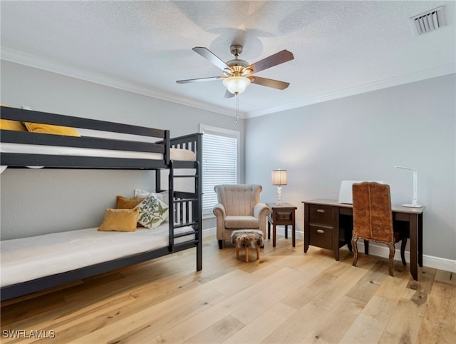 bedroom with light wood-type flooring, ornamental molding, ceiling fan, and a textured ceiling