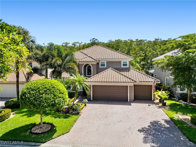 mediterranean / spanish-style home featuring a front yard and a garage