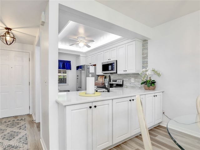 kitchen featuring light hardwood / wood-style flooring, white cabinets, appliances with stainless steel finishes, and ceiling fan