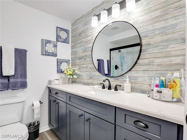 bathroom featuring toilet, walk in shower, vanity, wood walls, and hardwood / wood-style flooring