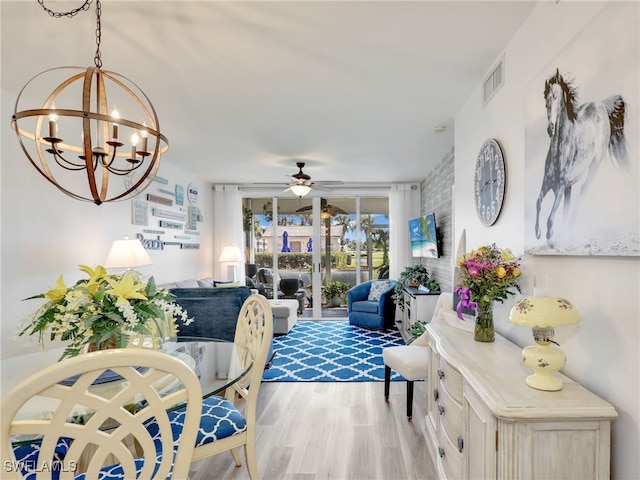 living room featuring light hardwood / wood-style flooring and ceiling fan with notable chandelier