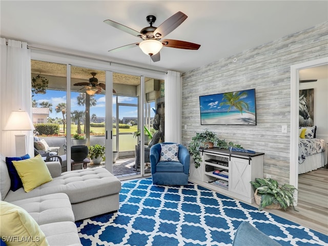 living room with light hardwood / wood-style flooring, ceiling fan, and expansive windows