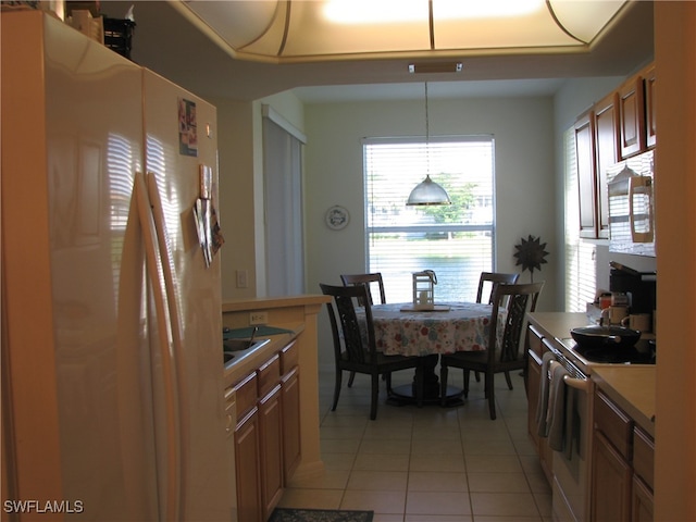 kitchen featuring hanging light fixtures, appliances with stainless steel finishes, and light tile patterned flooring