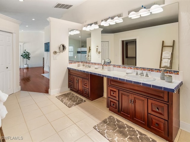 bathroom with tile patterned flooring, vanity, and ornamental molding