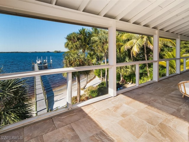 unfurnished sunroom with beam ceiling and a water view