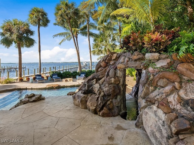 view of swimming pool with a water view and a patio