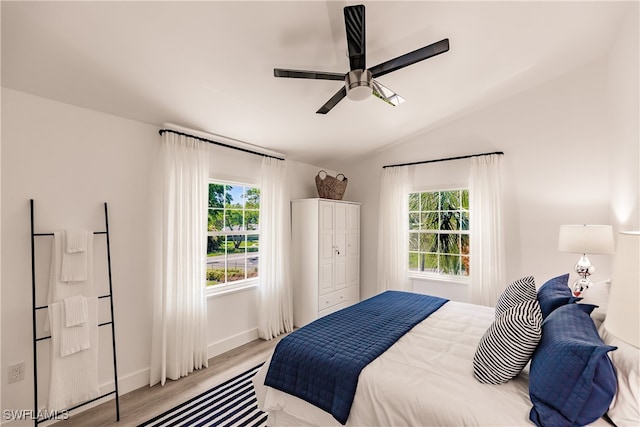 bedroom with vaulted ceiling, light hardwood / wood-style flooring, and ceiling fan