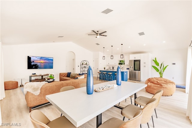 dining area with light hardwood / wood-style flooring, vaulted ceiling, and ceiling fan