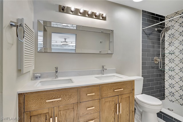 bathroom with tile patterned floors, tiled shower, toilet, and vanity