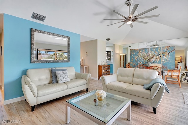 living room with ceiling fan, vaulted ceiling, and light hardwood / wood-style floors