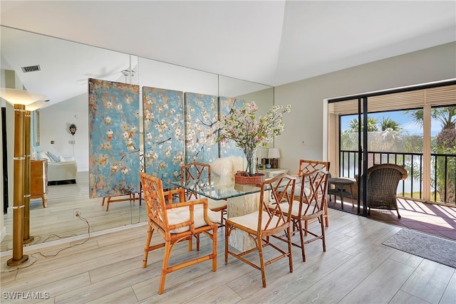 dining space with lofted ceiling and light hardwood / wood-style flooring