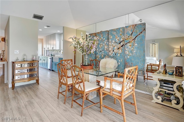 dining space featuring light wood-type flooring and sink