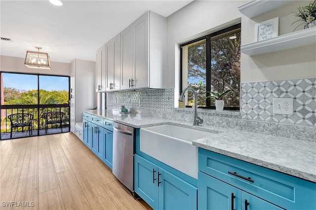 kitchen with blue cabinetry, sink, decorative backsplash, stainless steel dishwasher, and light hardwood / wood-style floors