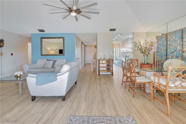 living room featuring light hardwood / wood-style flooring and ceiling fan