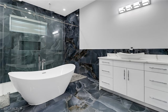 bathroom with vanity, tile walls, and separate shower and tub