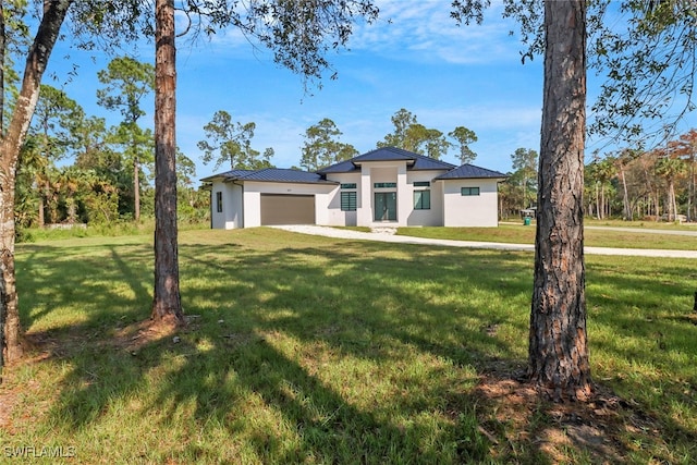 view of front of property featuring a front yard and a garage