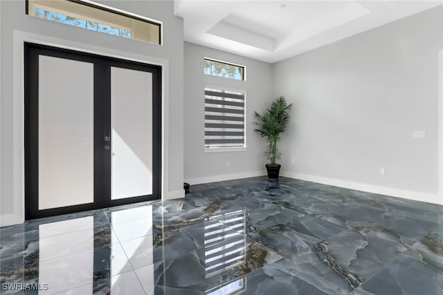 foyer entrance with french doors and a tray ceiling