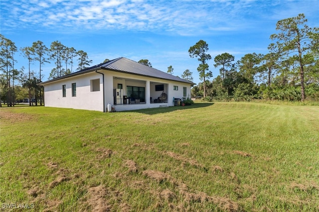 rear view of house featuring a lawn