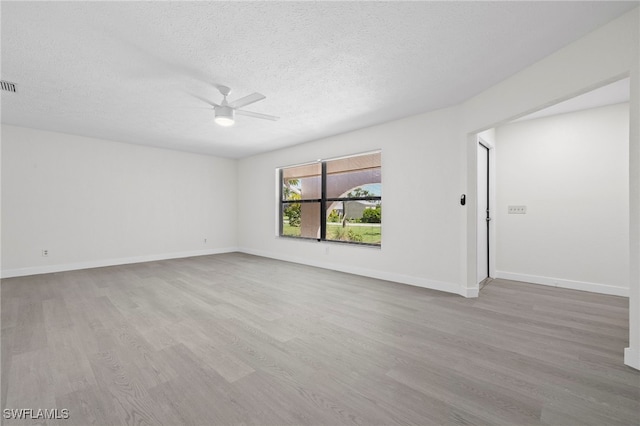 empty room featuring ceiling fan, a textured ceiling, and light hardwood / wood-style flooring