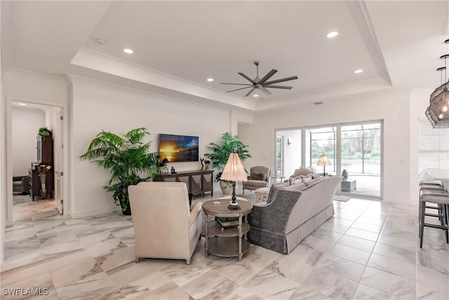 living room with ceiling fan, crown molding, and a tray ceiling