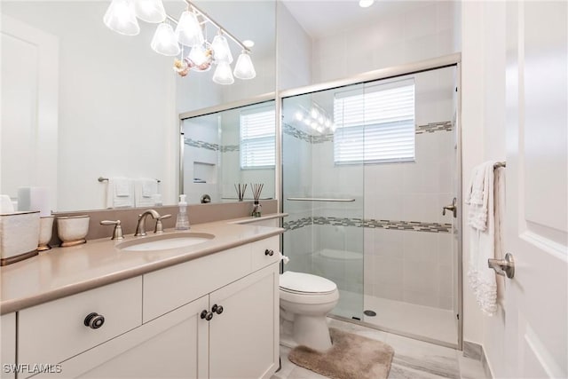 bathroom with vanity, toilet, and a shower with door