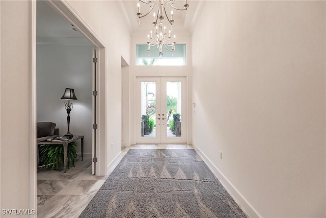 entryway with french doors, an inviting chandelier, and a high ceiling