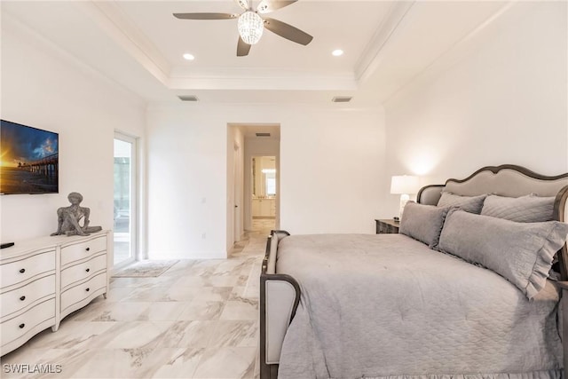 bedroom featuring ceiling fan, connected bathroom, and a tray ceiling