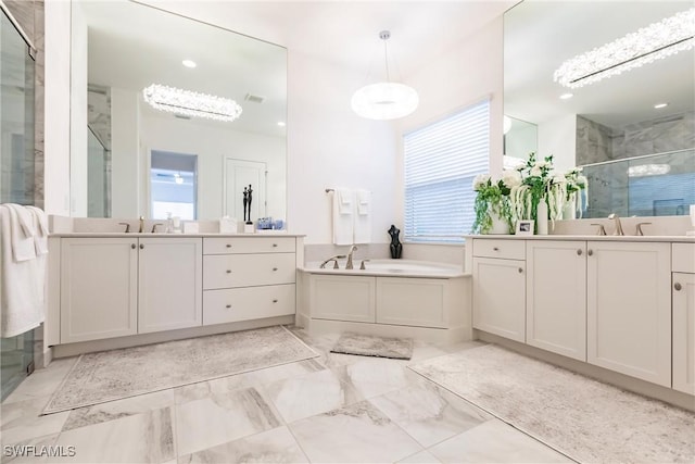 bathroom with a chandelier, vanity, and separate shower and tub