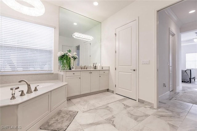 bathroom with vanity, a bathtub, and a healthy amount of sunlight