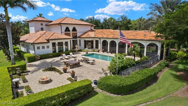 back of property featuring a fire pit and a patio