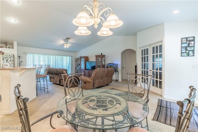 carpeted dining room featuring ceiling fan with notable chandelier, lofted ceiling, and french doors