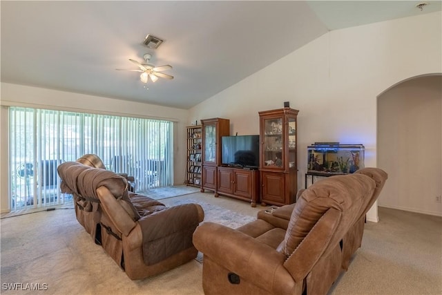 carpeted living room with ceiling fan and high vaulted ceiling