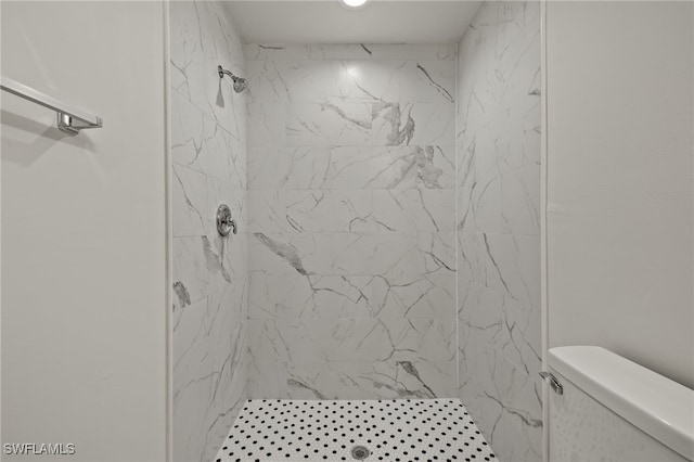 bathroom featuring toilet and a tile shower