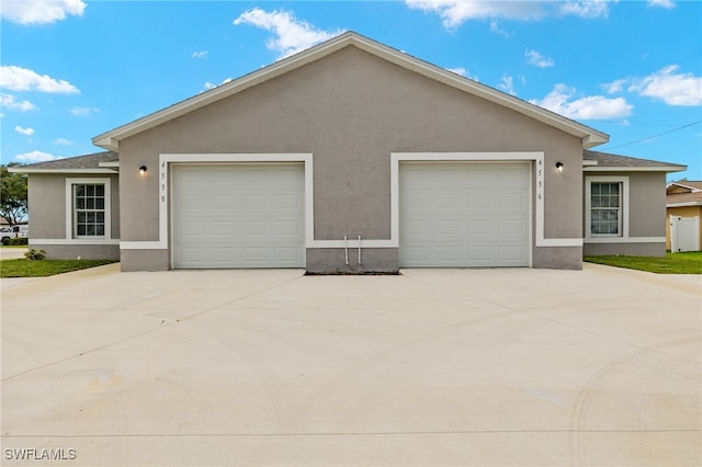 view of front of house featuring a garage, concrete driveway, and stucco siding