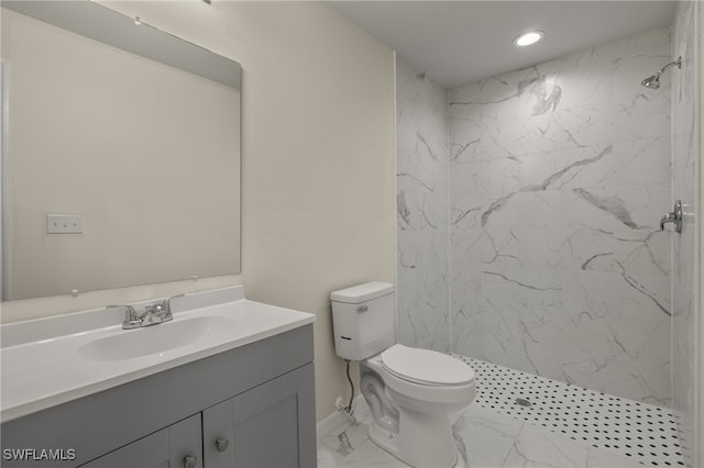 bathroom featuring vanity, toilet, and a tile shower