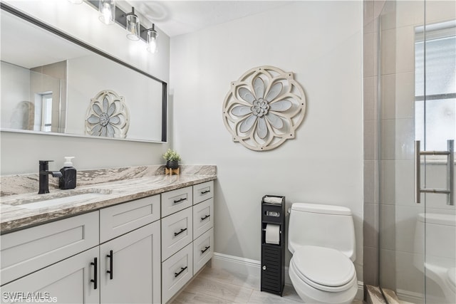 bathroom with a shower with door, toilet, vanity, and tile patterned flooring