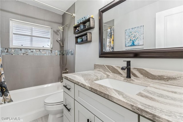 bathroom with toilet, shower / bathtub combination with curtain, and vanity