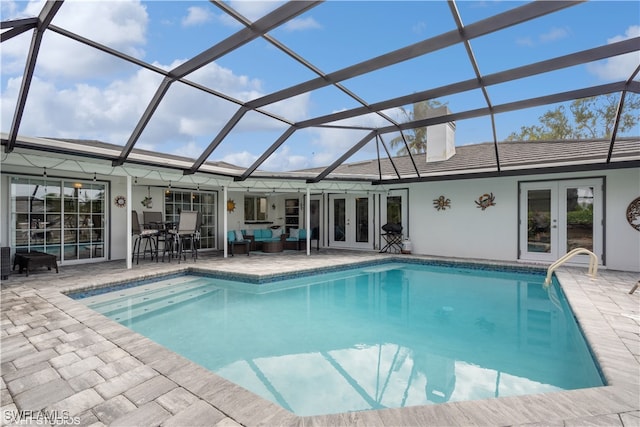 view of swimming pool featuring glass enclosure, a patio, french doors, and an outdoor living space