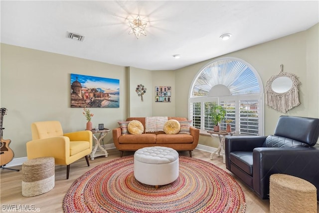 sitting room featuring light wood-type flooring, visible vents, and baseboards