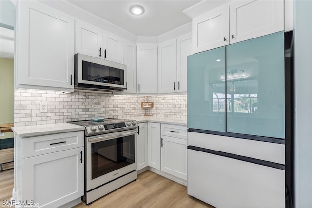 kitchen with stainless steel electric stove, light hardwood / wood-style flooring, white refrigerator, white cabinets, and light stone countertops