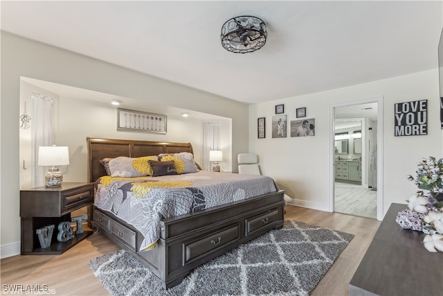 bedroom with light wood-type flooring and ensuite bathroom