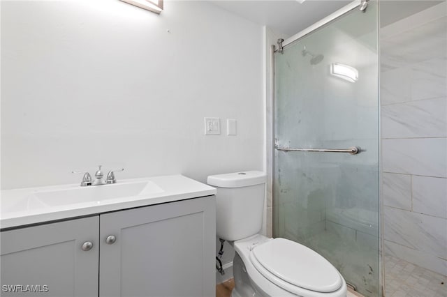 bathroom featuring toilet, a shower with door, and vanity