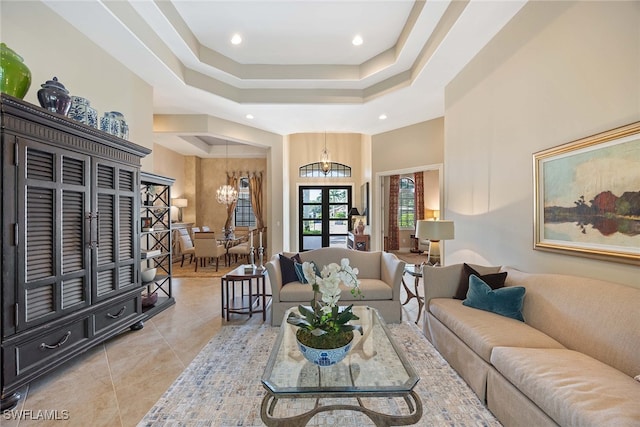 tiled living room featuring an inviting chandelier and french doors